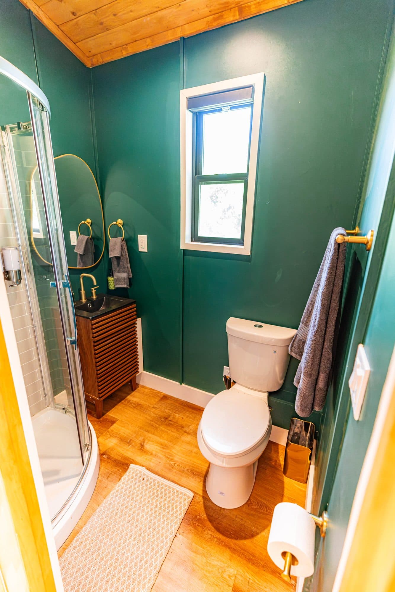 Bathroom with green walls, a toilet and a window