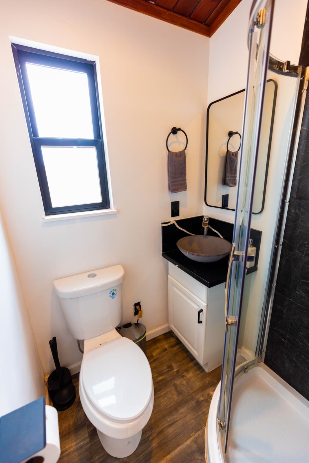 Bathroom with a vessel sink, toilet and glass shower