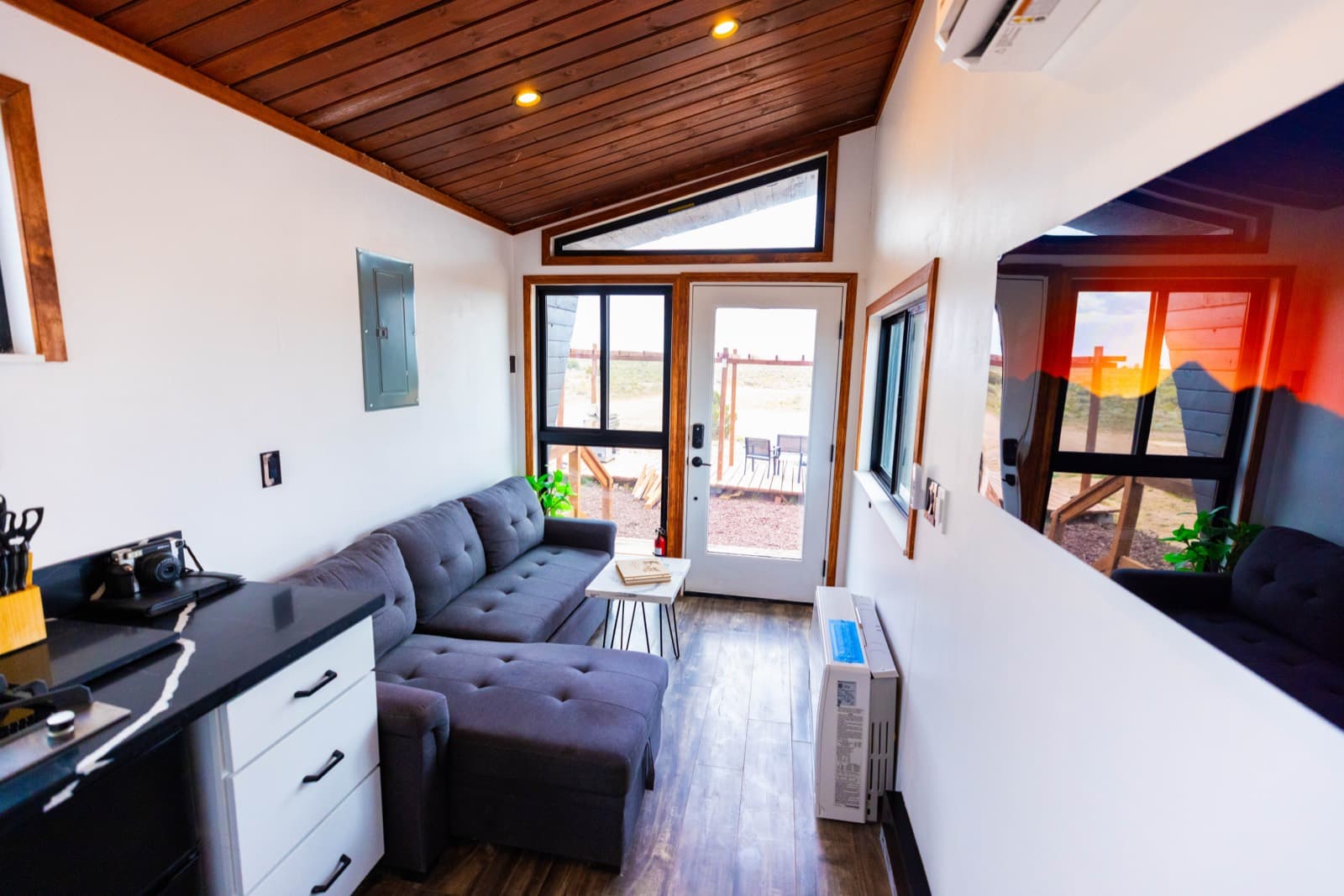 Gray sectional sofa facing a glass door to the deck