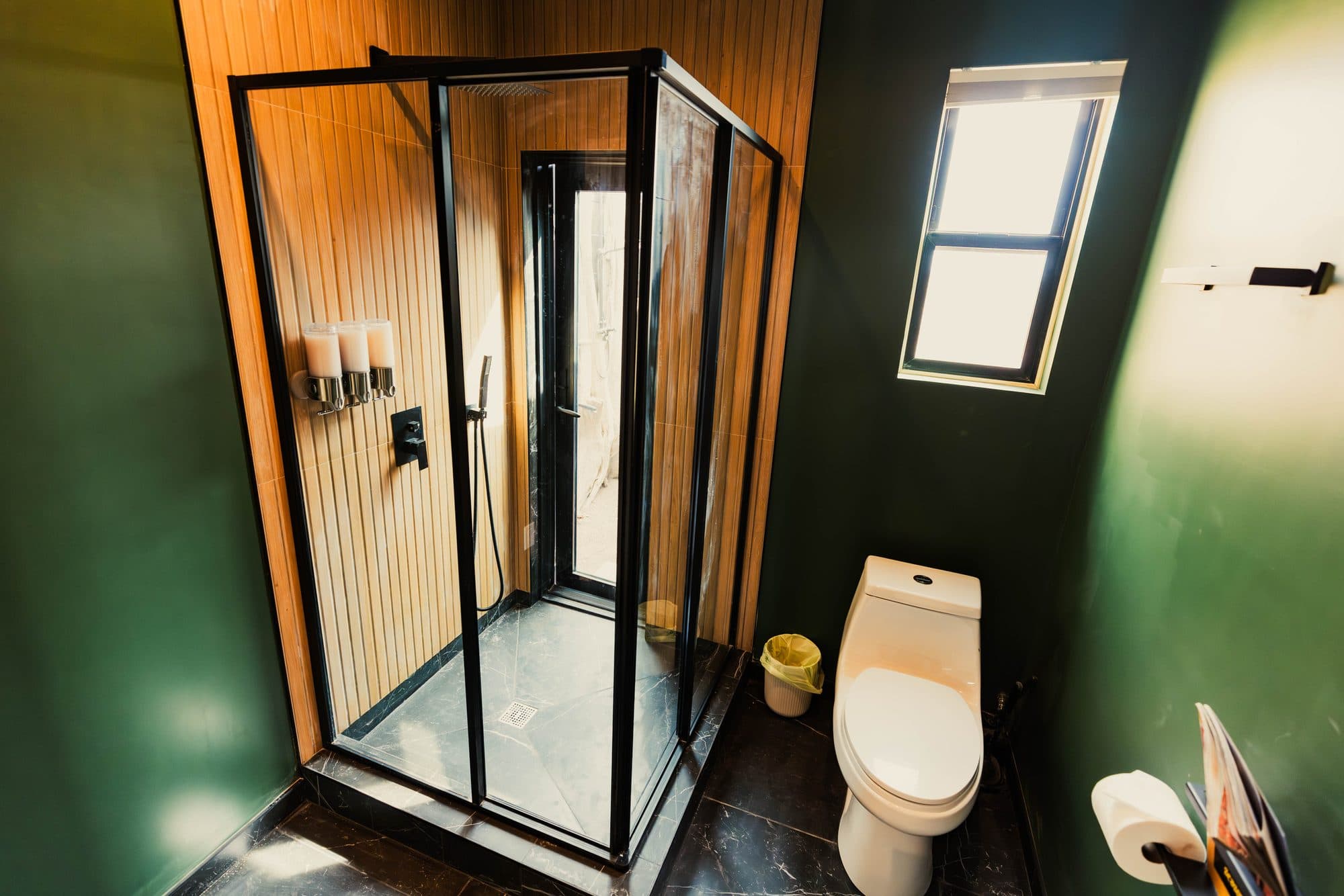 Glass shower with a wood-slat wall, next to the toilet