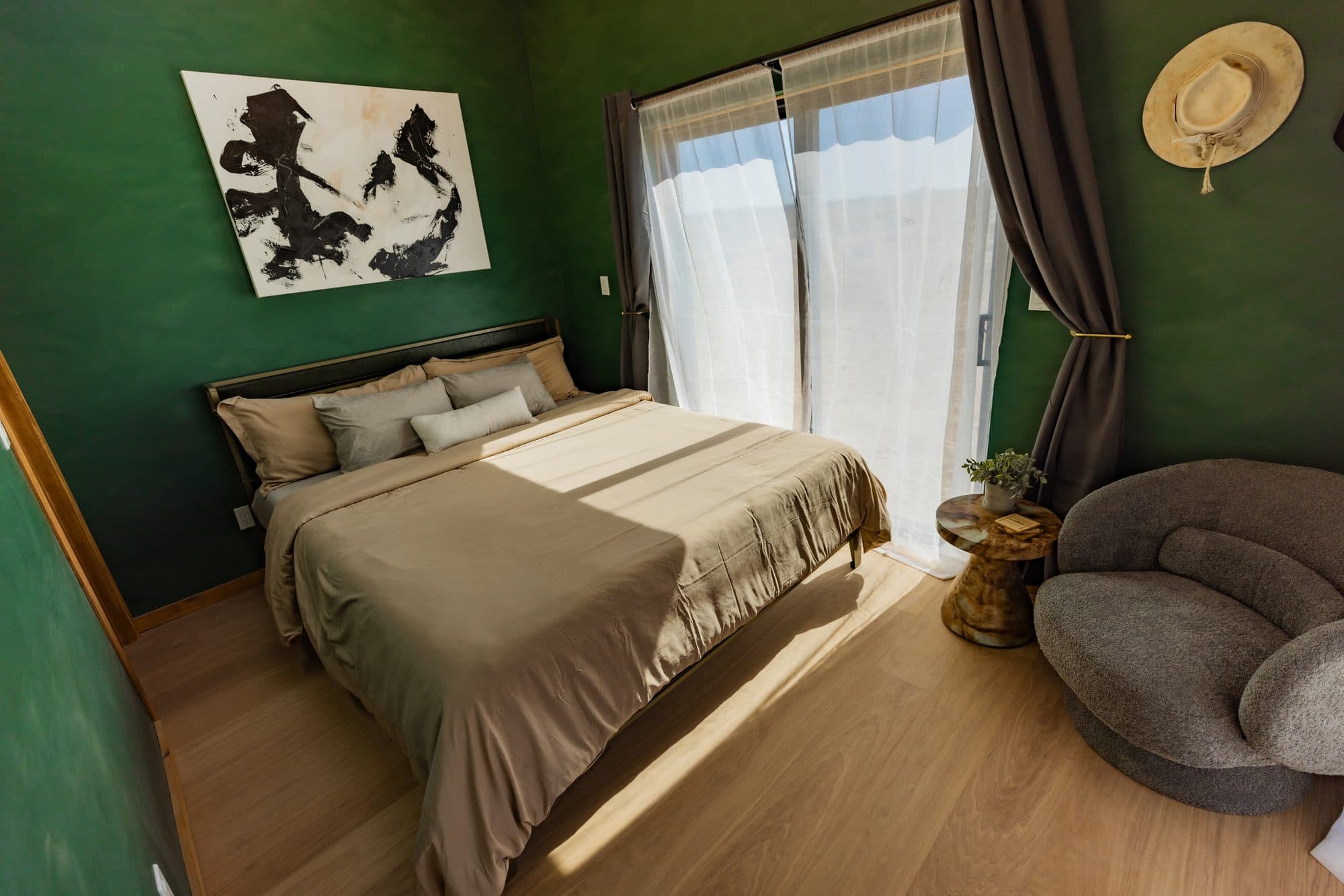 Bedroom with green walls, the bed and sheer curtains
